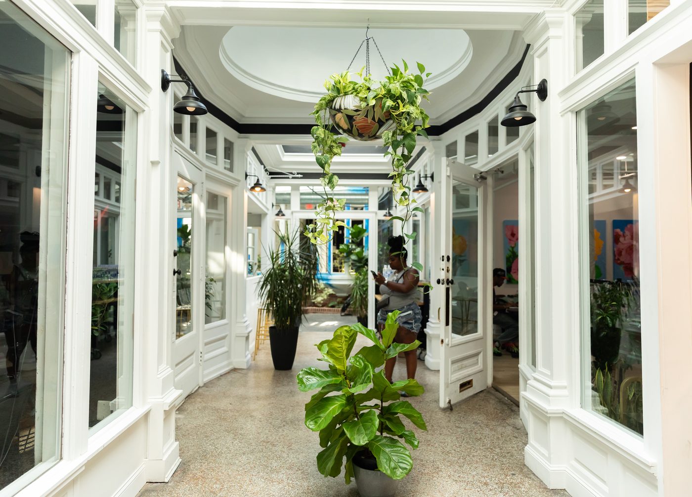 The plant-lined hallway connecting the spaces at Stem & Vine in Baltimore