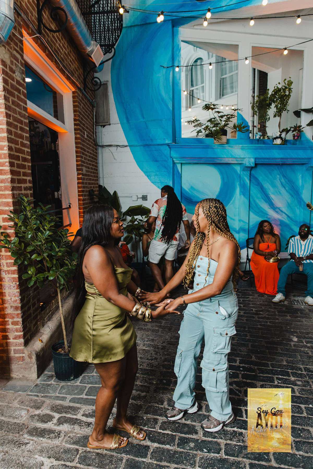 A couple beside the blue mural in the courtyard at Stem & Vine, Baltimore