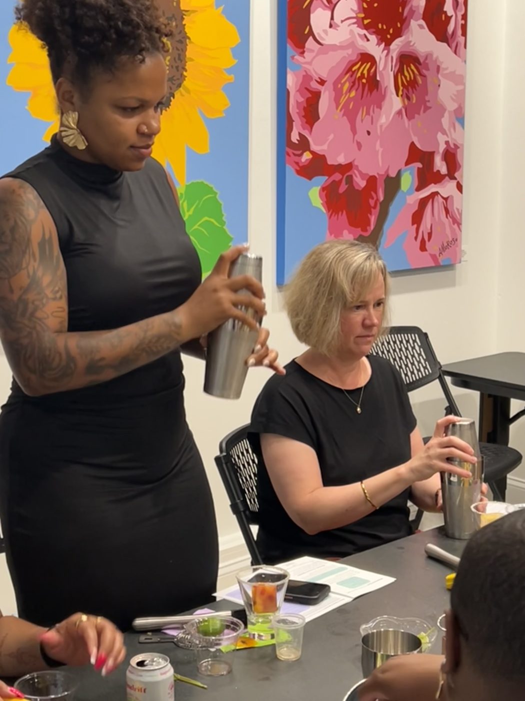 A guest shaking a cocktail tin at the table during a botanical mixology class in the Gallery at Stem & Vine, Baltimore