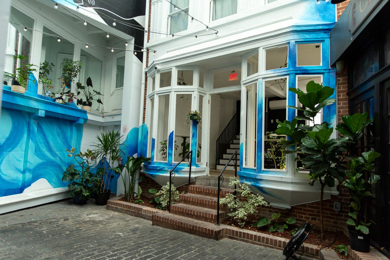 The blue mural and shop entrance in the Browns Arcade courtyard at 326 N Charles St, Baltimore