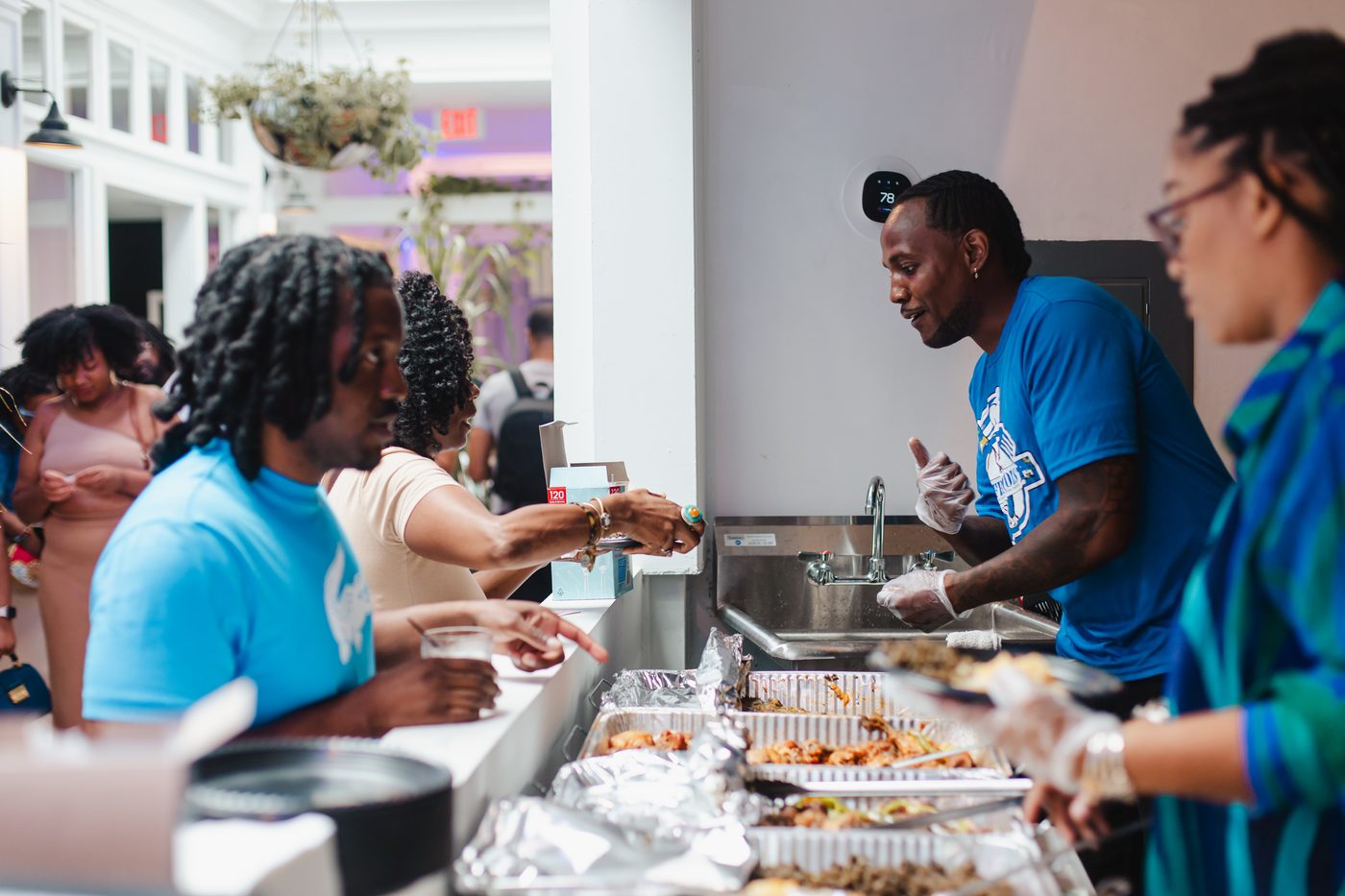 A catering team serving guests from a buffet line at Stem & Vine in Baltimore