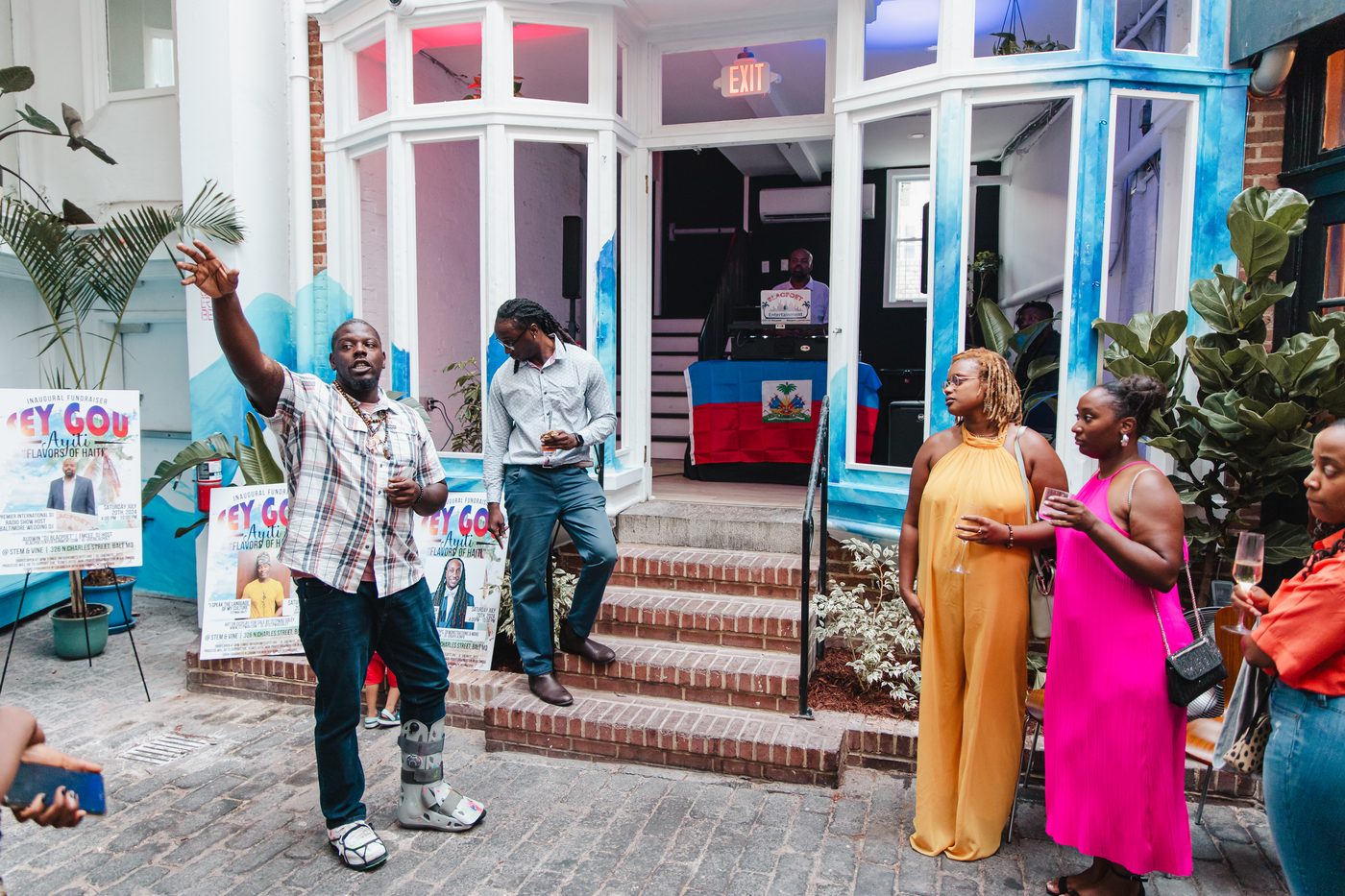 Guests celebrating on the courtyard steps beneath the mural at Stem & Vine, Baltimore