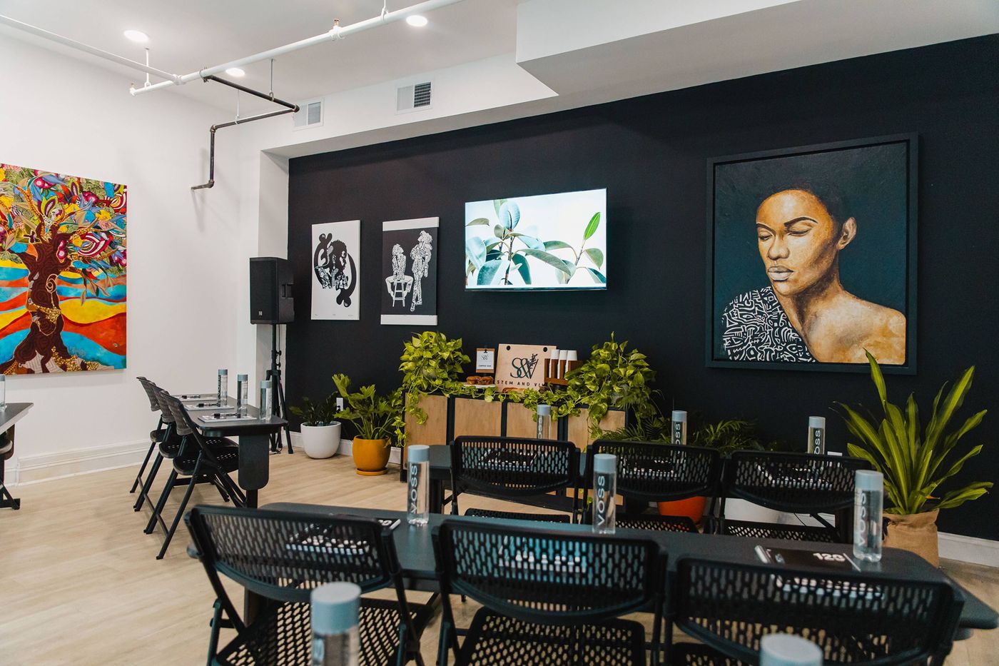 The Stem Room set with long tables under its art wall at Stem & Vine, Baltimore