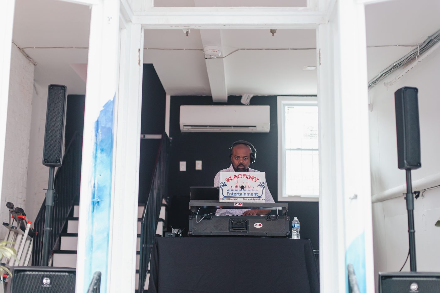 DJ playing a groove house Radio set between the doorways at Stem & Vine in Baltimore