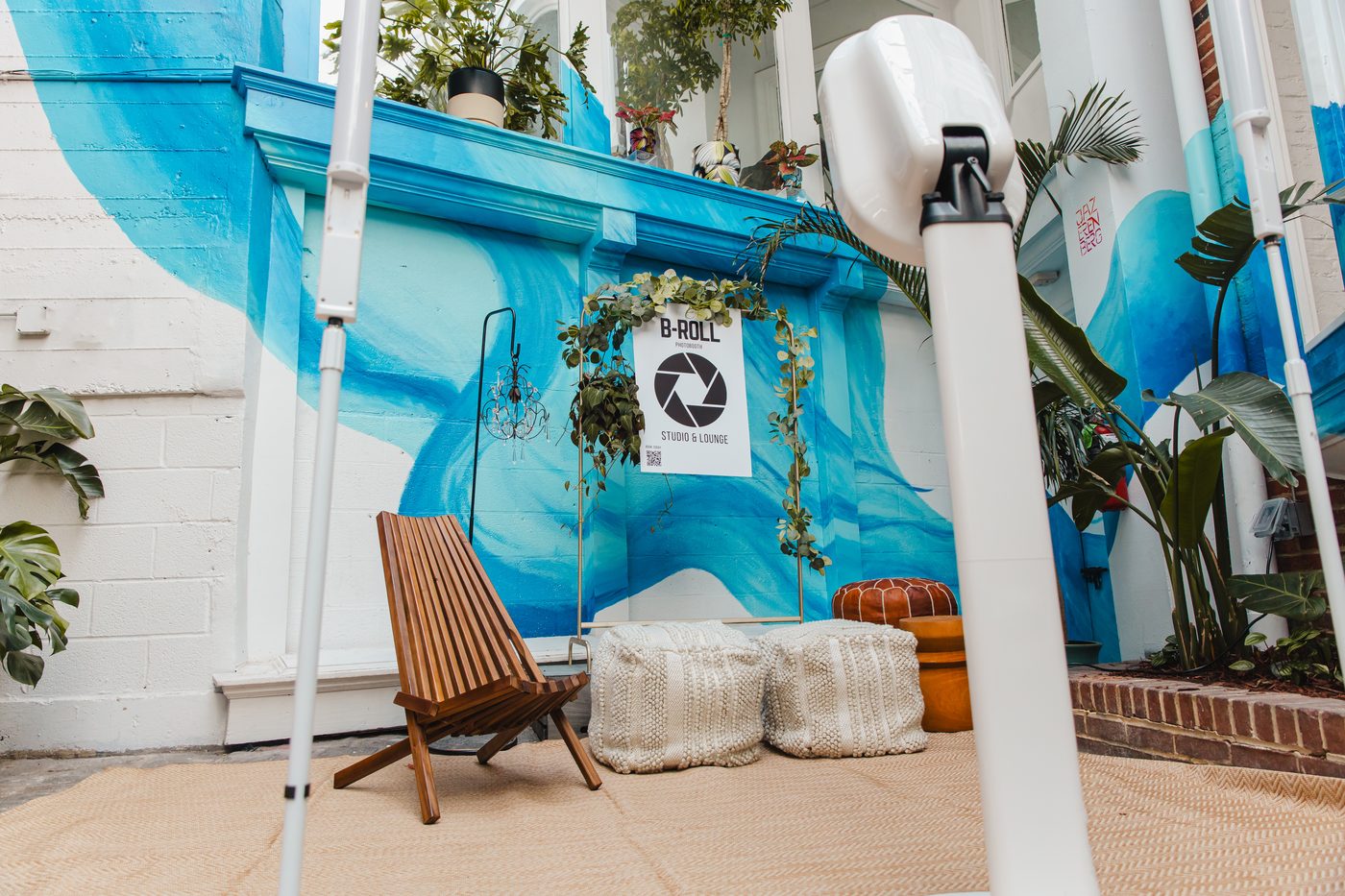 Lounge chairs and the photo corner set up along the mural wall of the courtyard at Stem & Vine