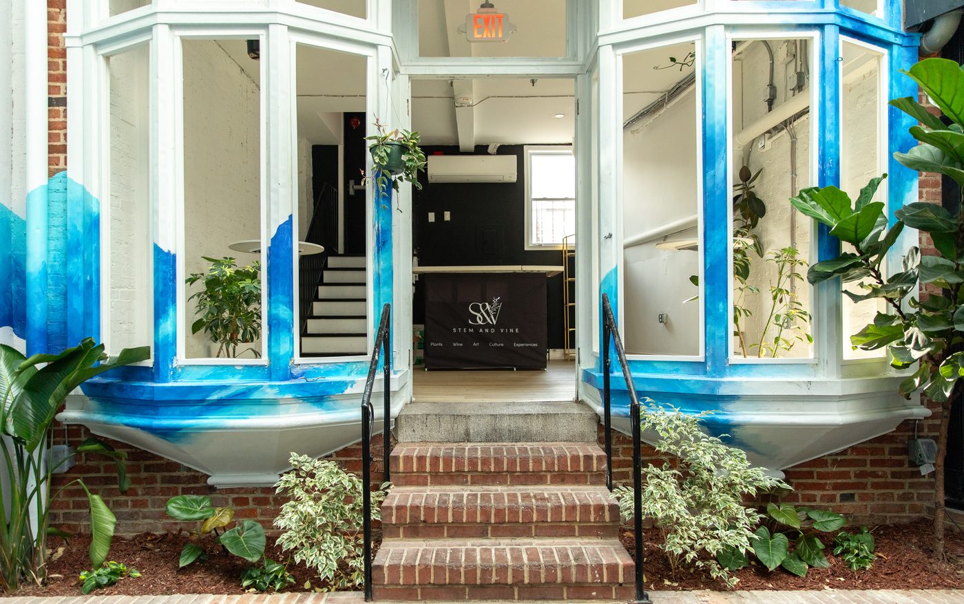 Brick steps and the blue mural at the courtyard entrance of Stem and Vine, Baltimore
