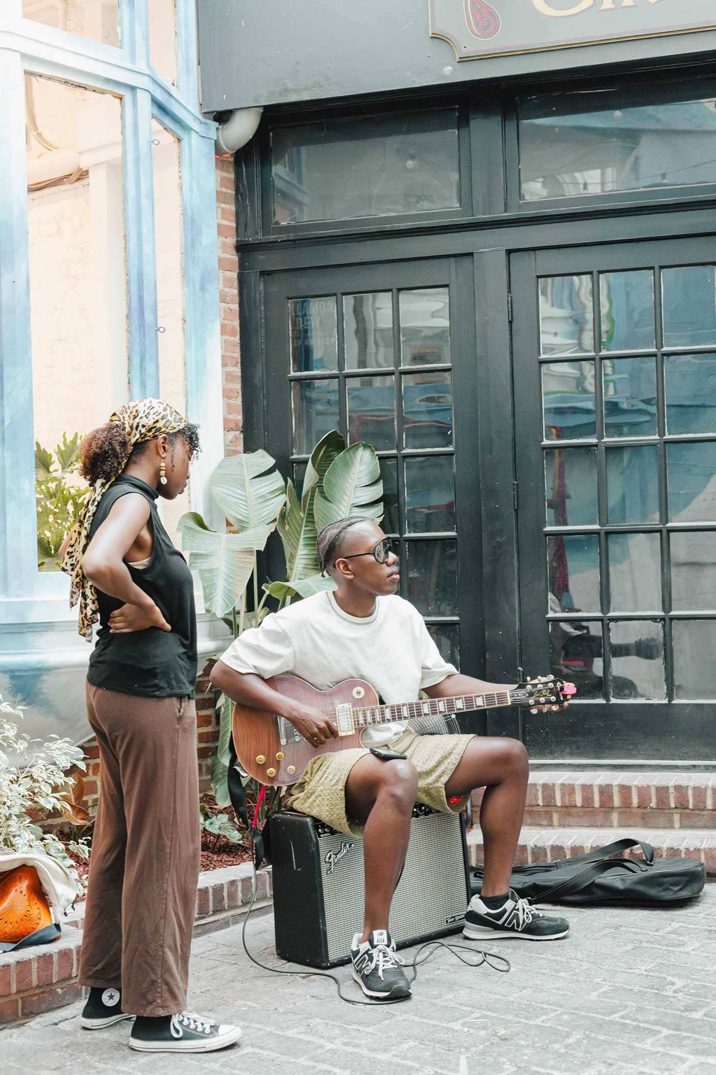 Guitarist playing beside the monstera in the Stem & Vine courtyard, Baltimore