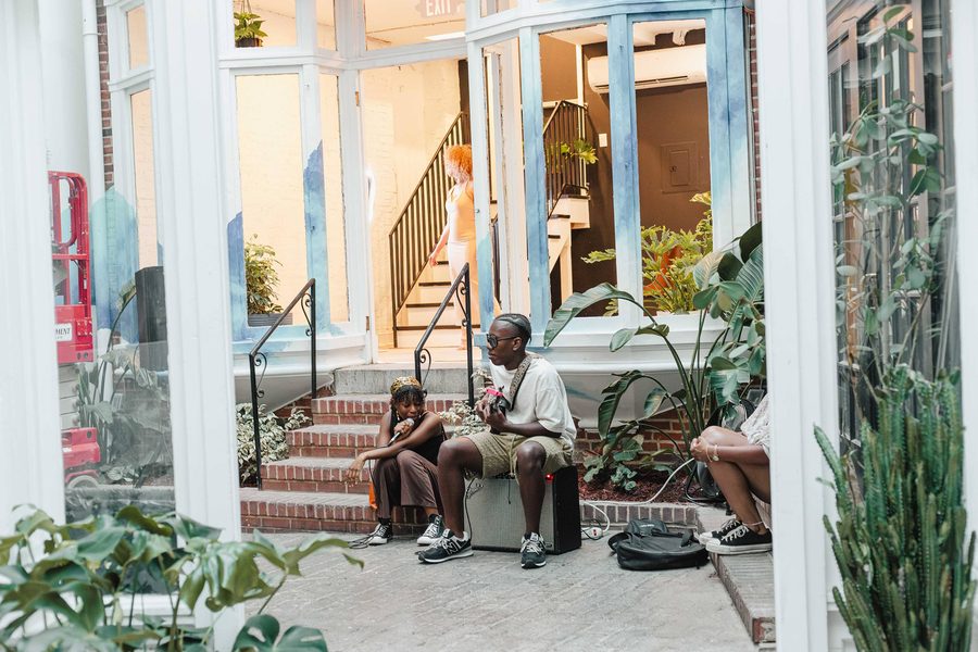A guest sitting on the brick courtyard steps under the skylight at Stem & Vine in Baltimore