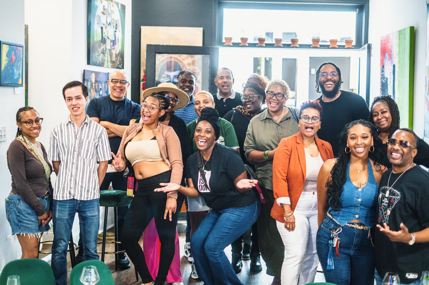 A large group of guests posing together in front of the art wall at Stem & Vine in Baltimore