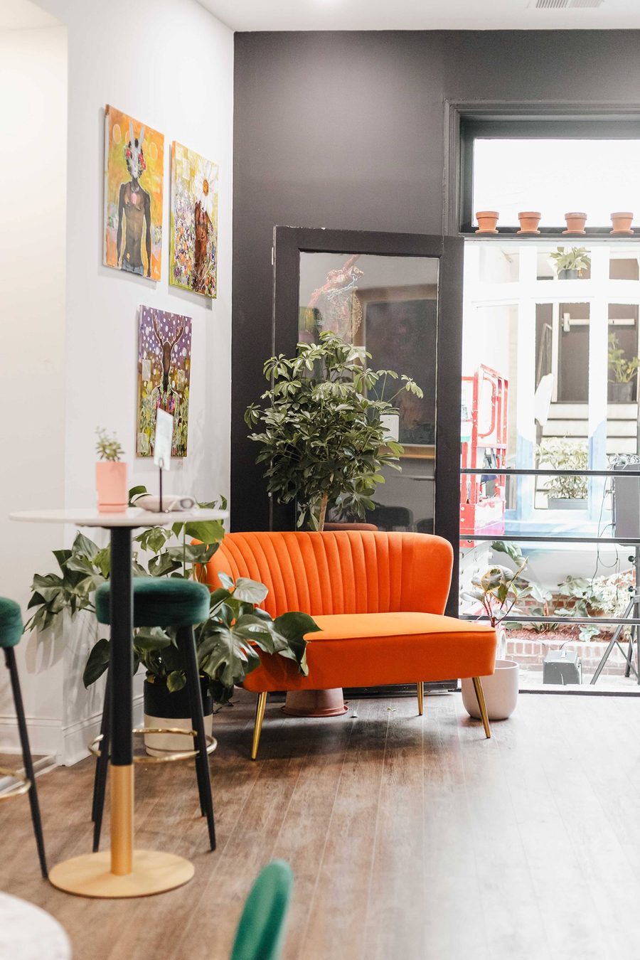 Orange velvet sofa in a sunlit corner by the street windows at Stem & Vine, Baltimore