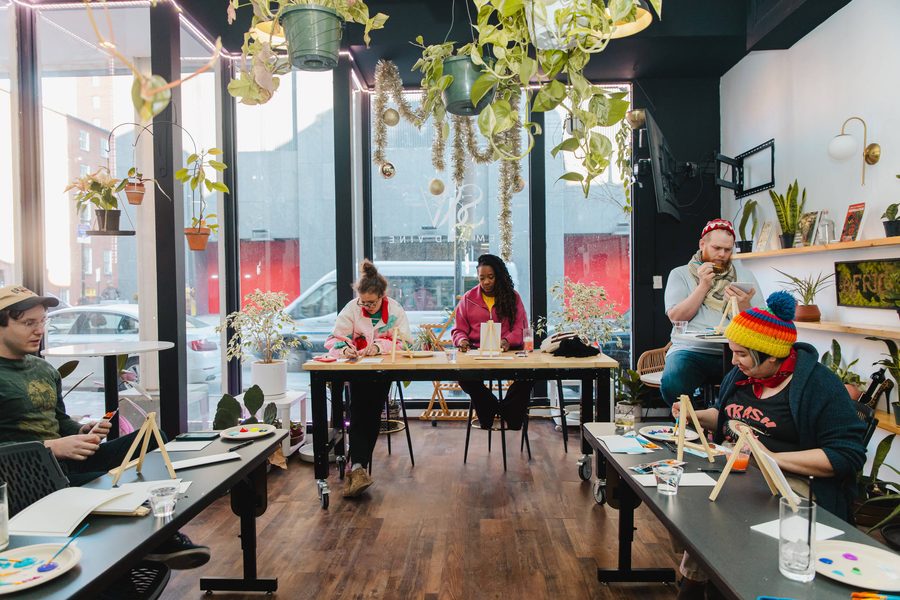 Guests painting at long tables during a workshop at Stem & Vine in Baltimore