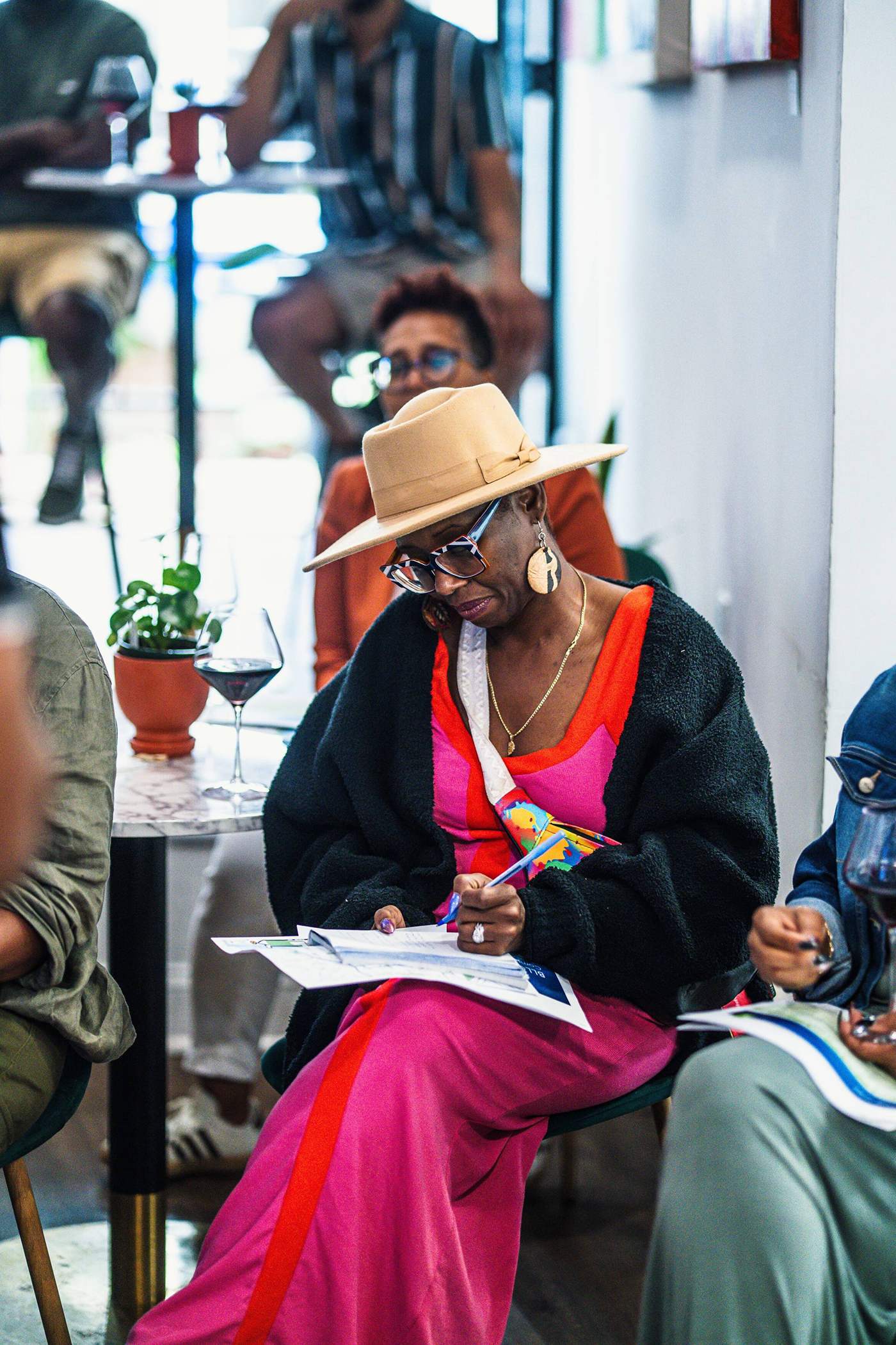 Guest writing at a table surrounded by plants at Stem & Vine in Baltimore