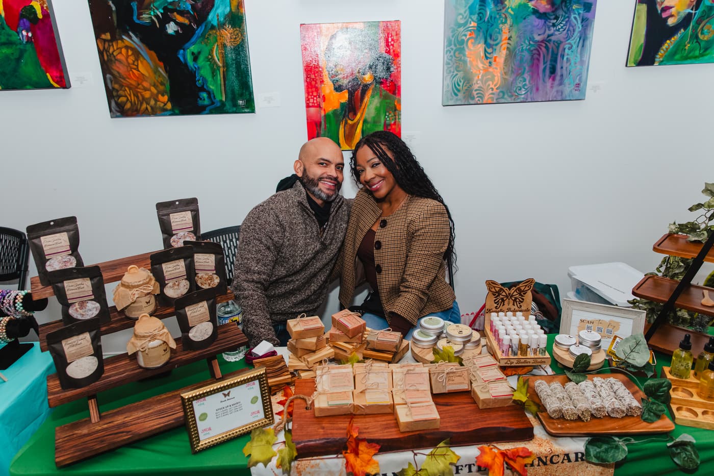 Two vendors behind a table of handmade goods during a market at Stem & Vine in Baltimore