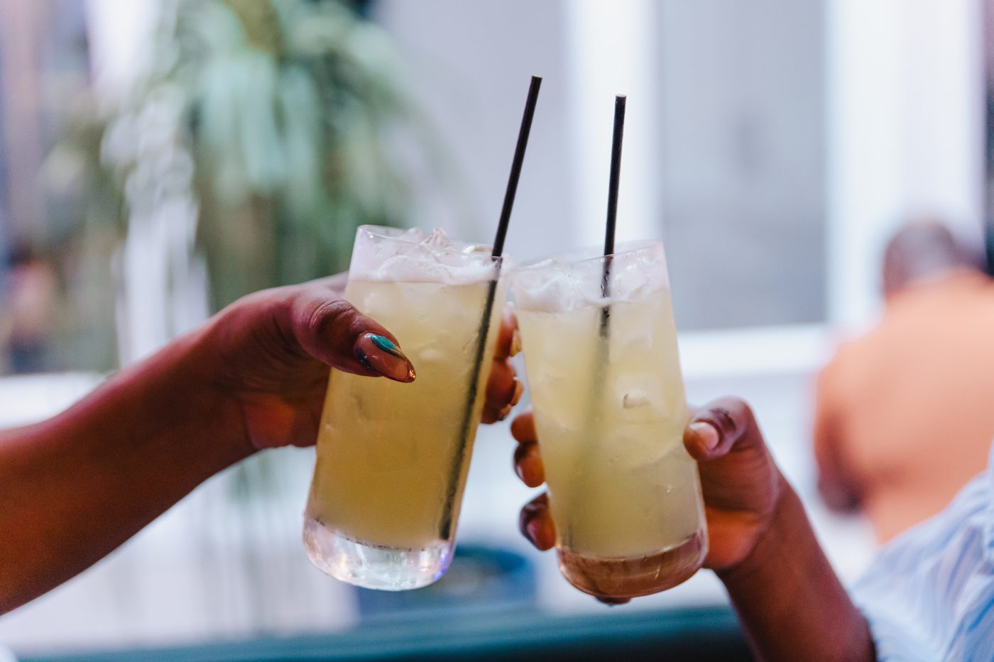 Two guests touching glasses over cocktails at Stem & Vine in Baltimore