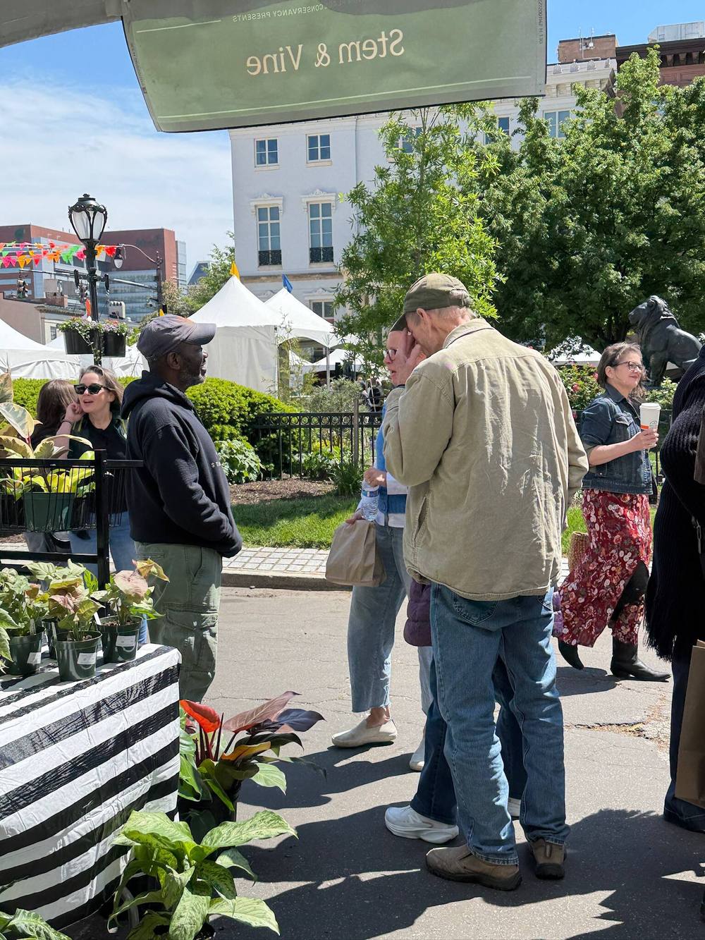 Flowering plants and shoppers at a Stem & Vine outdoor market in Baltimore