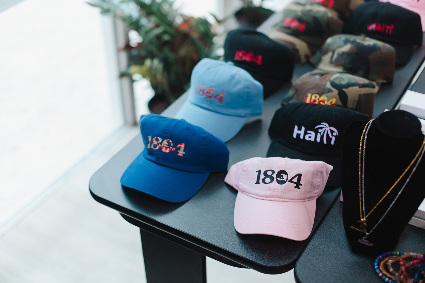 Embroidered caps laid out on a vendor table during a pop-up market at Stem & Vine, Baltimore