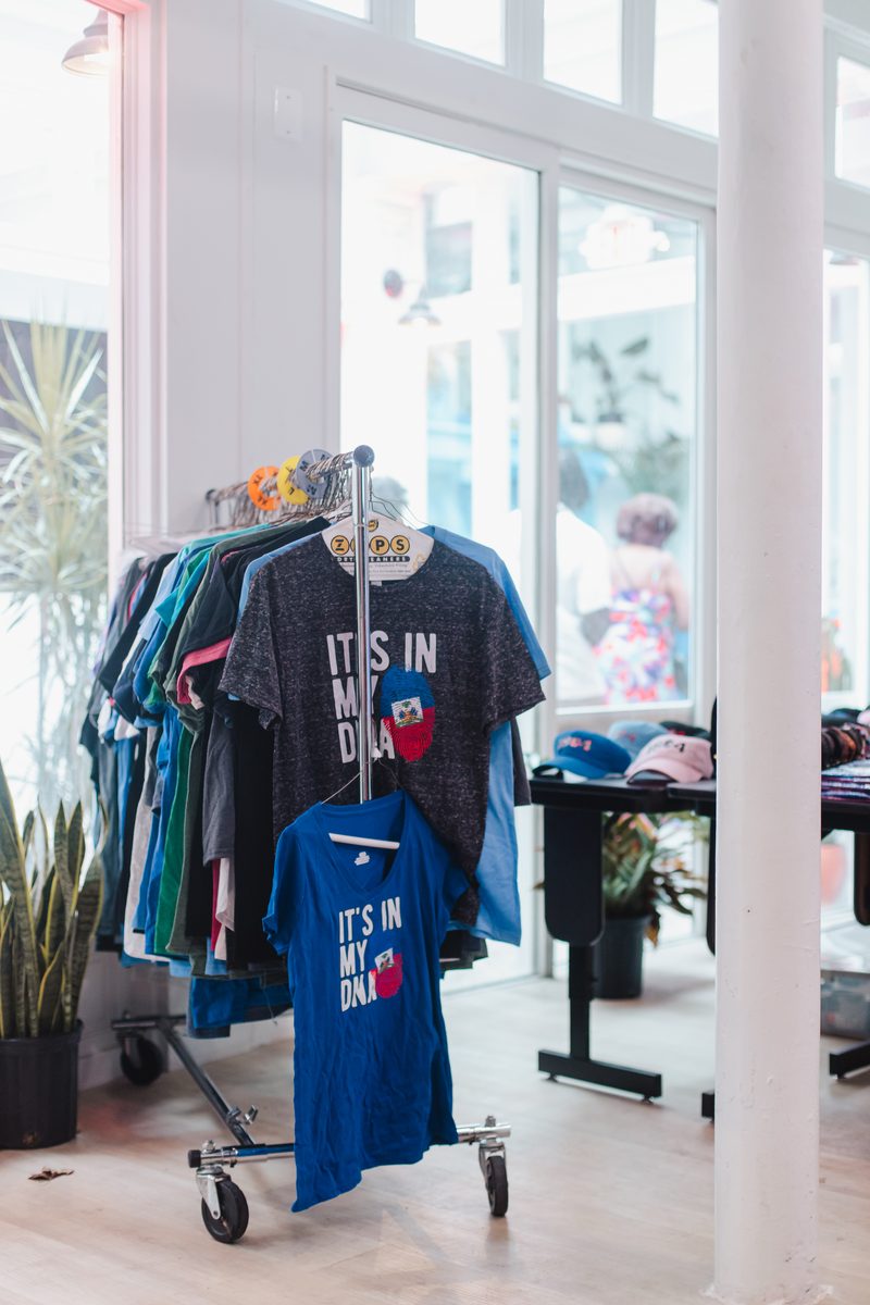 Racks of vendor tees in the front windows during a pop-up market at Stem & Vine in Baltimore