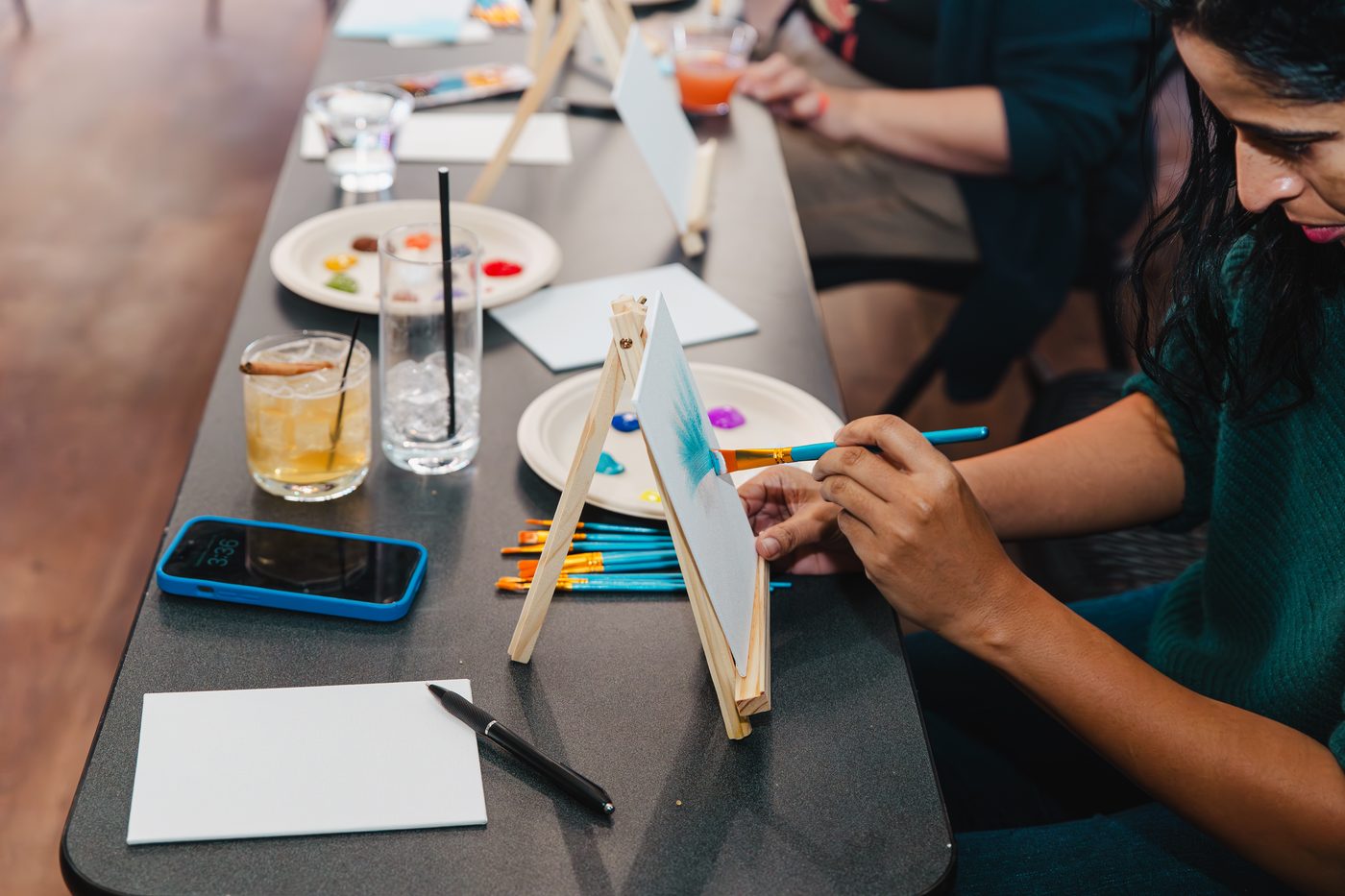 A guest painting at an easel during a team workshop at Stem & Vine in Baltimore