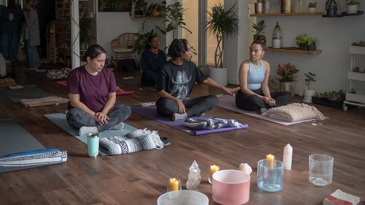 A seated wellness circle with candles and singing bowls at Stem & Vine, Baltimore