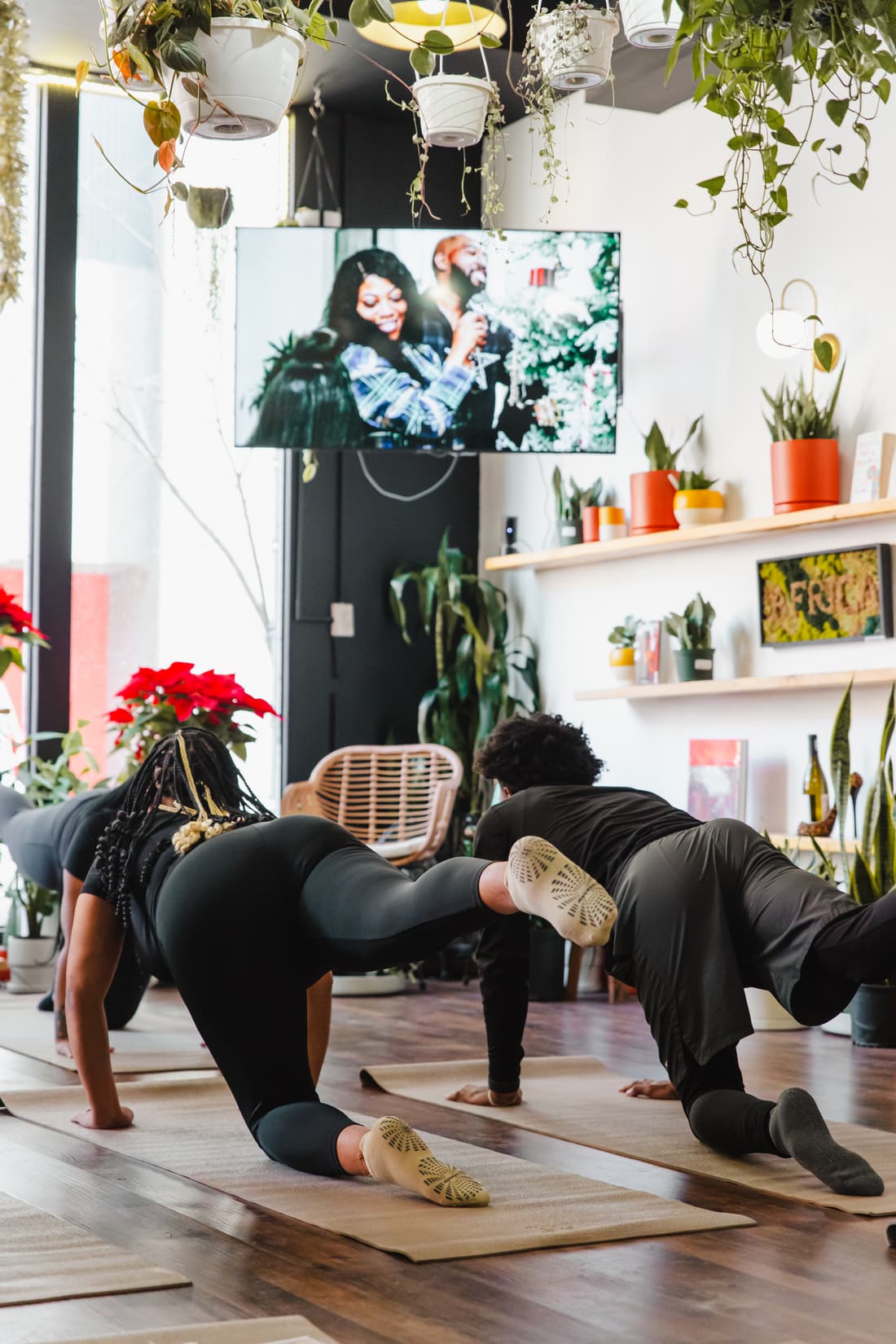 Guests stretching on mats during a wellness class surrounded by plants at Stem & Vine, Baltimore
