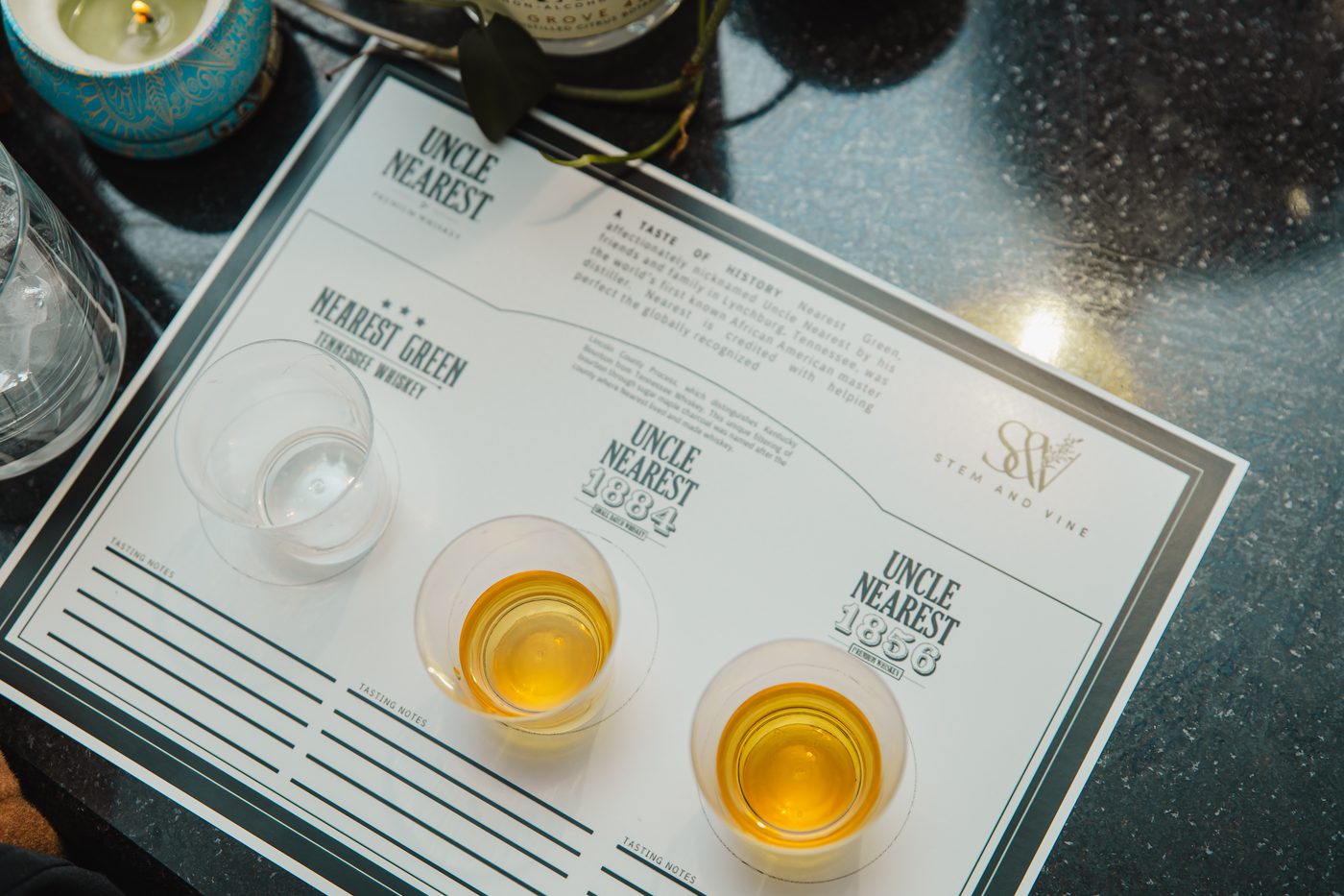 A whiskey tasting flight card with pours lined up at Stem & Vine in Baltimore