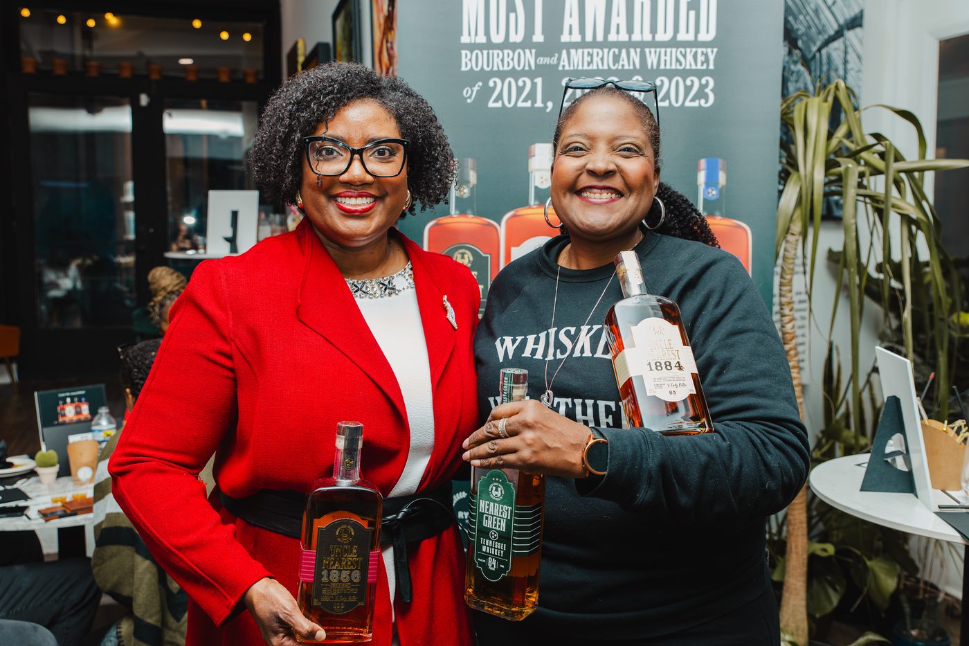 Hosts with bottles at a whiskey tasting night at Stem & Vine in Baltimore